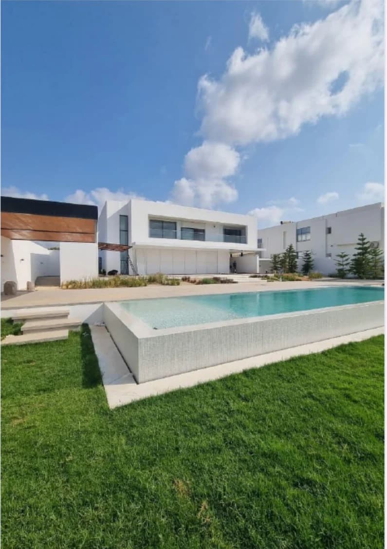 Piscine extérieure entourée d’une pelouse aménagée