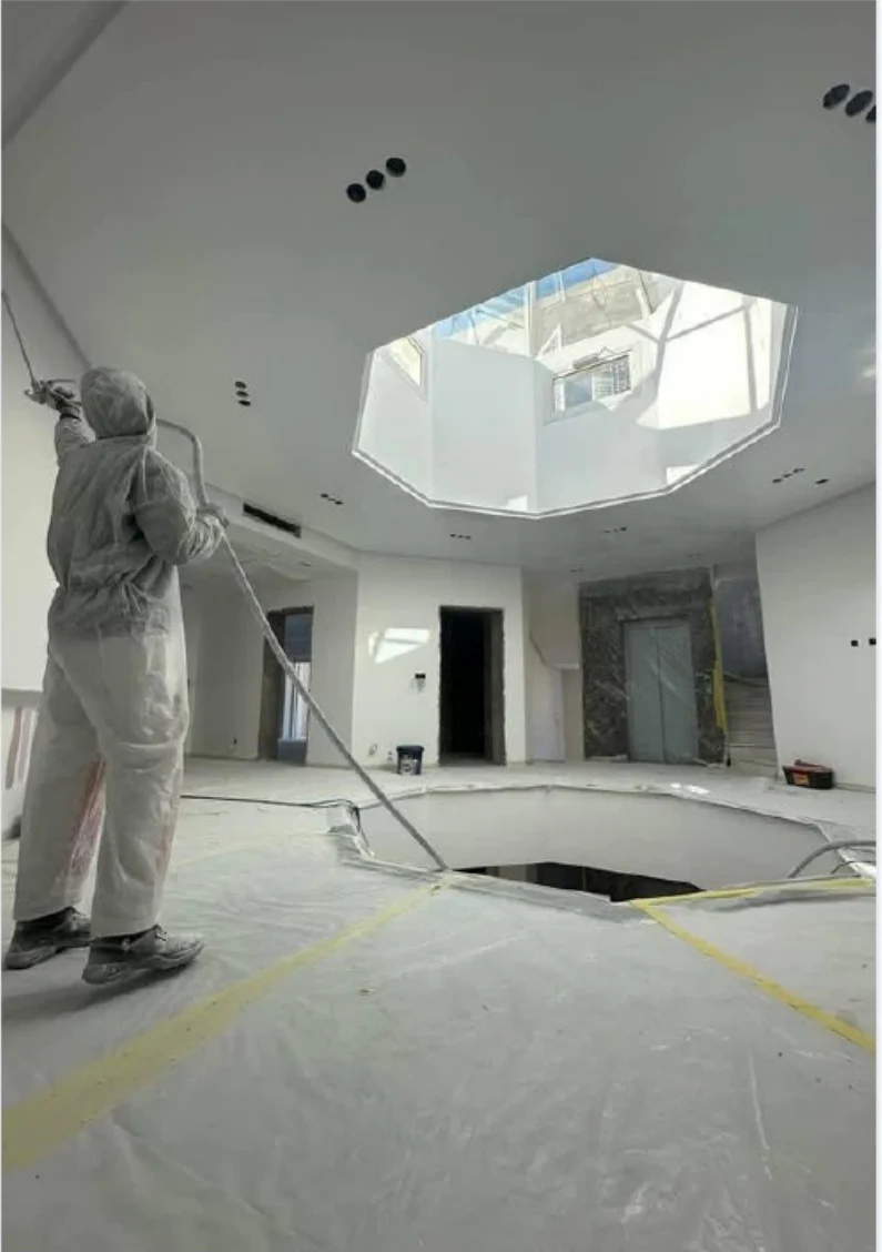 Travaux de peinture dans un hall avec ouverture zénithale